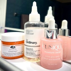 Flatlay of skincare products used before makeup, including toner, serum, and moisturizer