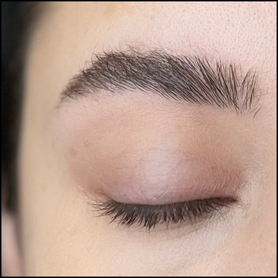 Finished fluffy eyebrow look with brushed-up hairs, filled-in sparse areas, and brow gel for hold and lift