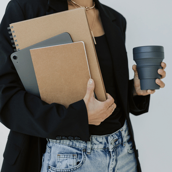 woman in jeans and blazer holding books